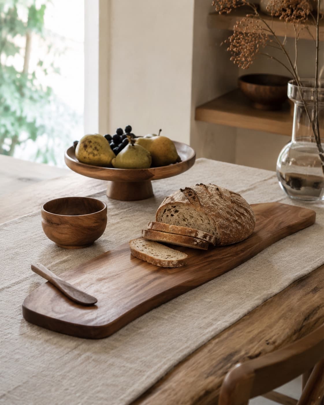 Wooden serving board and spreader arranged with simple food on a dining table